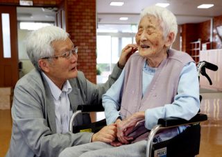 母良枝さん（右）の手を取る平野さん＝６月１２日、長崎市三ツ山町、恵の丘長崎原爆ホーム