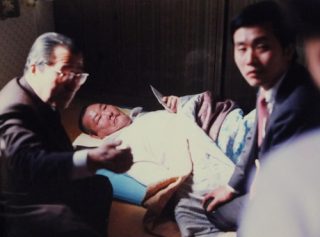 初めて訪韓し、寝たきりの被爆者を見舞う平野さん（右）＝１９８７年、ソウル（平野さん提供）