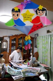 自宅で紙芝居の制作をする三田村さん。子どもたちからもらった感謝の手紙は宝物だ＝長崎市内